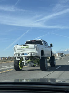 white lifted truck with green accents driving on Pyramid Hwy